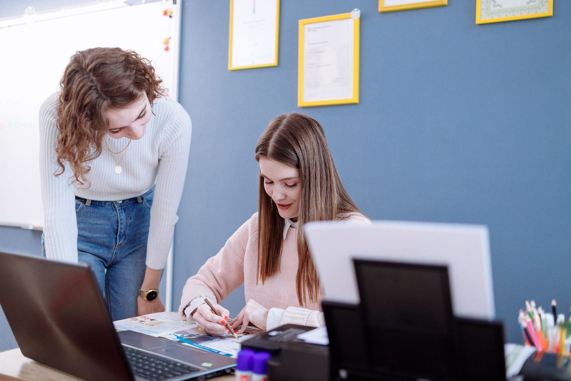 Nachhilfelehrerin bespricht Lernunterlagen mit einer Schülerin am Tisch