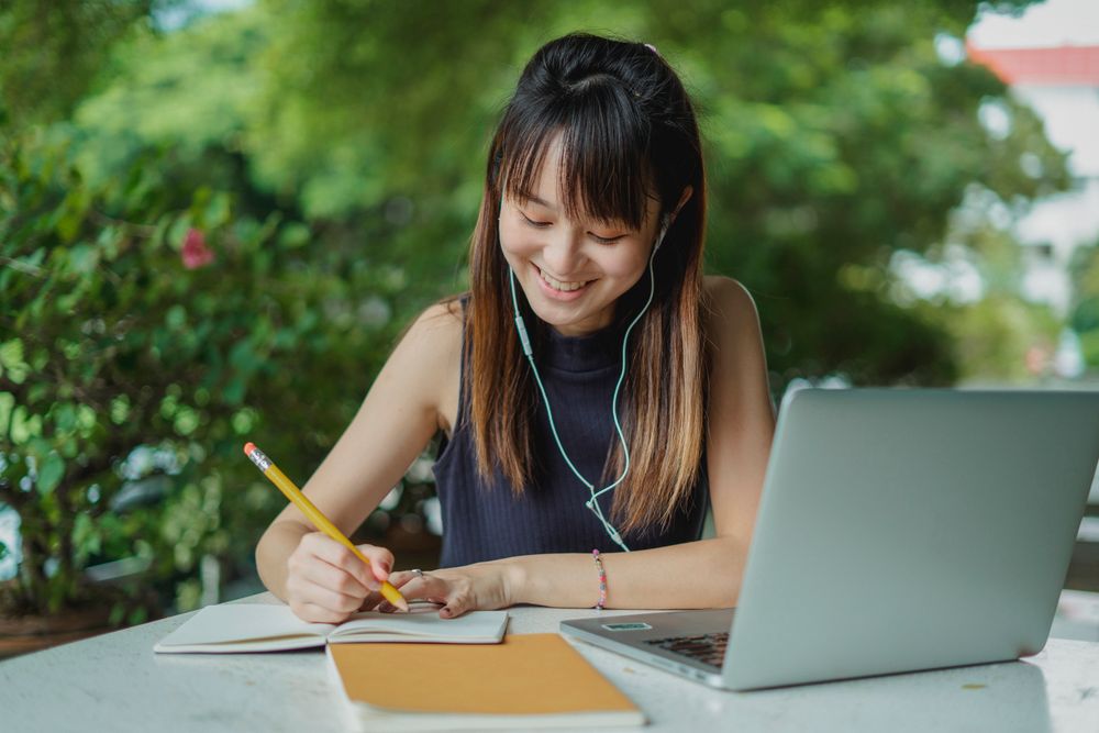 Schülerin mit Kopfhörern beim Vokabellernen